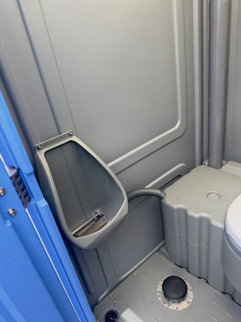 Urinal inside a gray porta potty